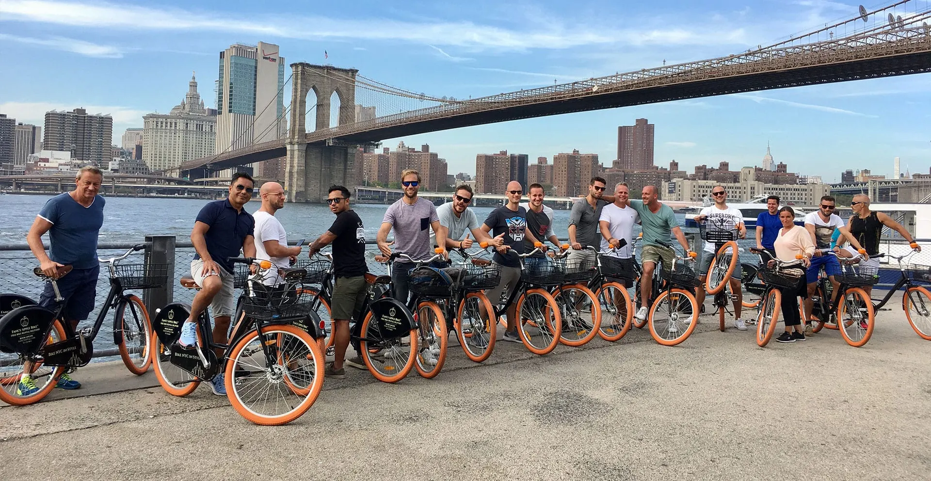 Large group lined up with rental bikes before a ride at the Brooklyn Bridge location