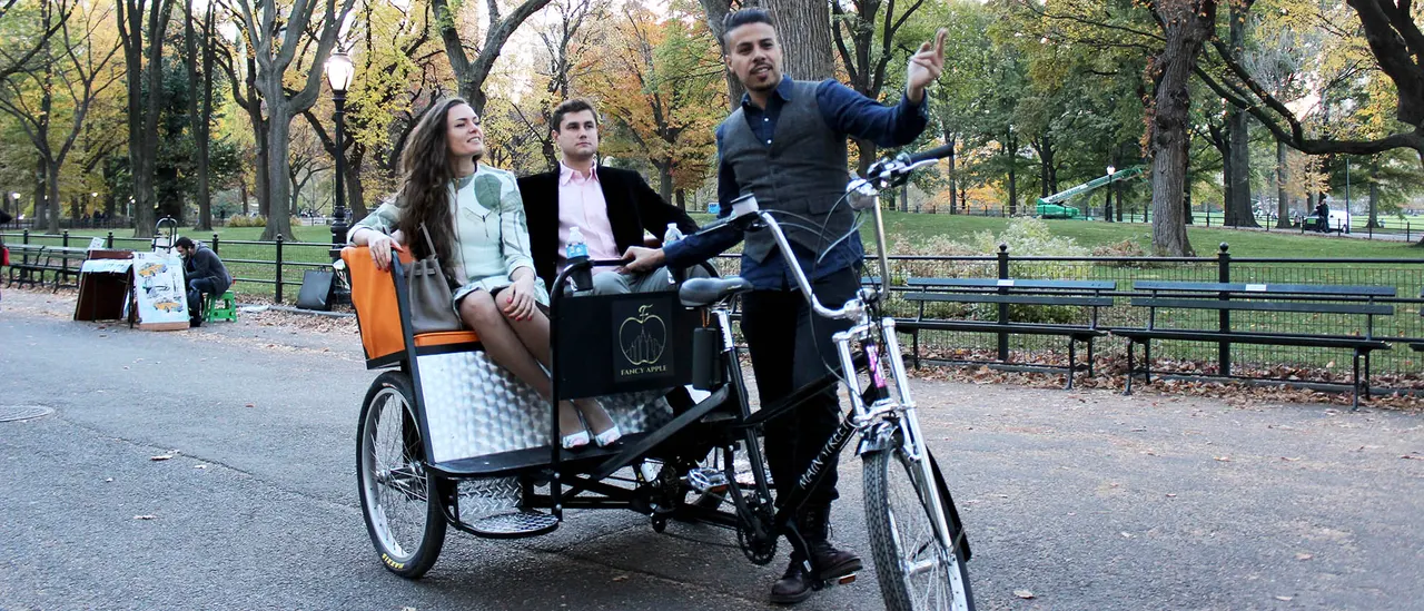 Guide with two guests on a pedicab ride in Central Park